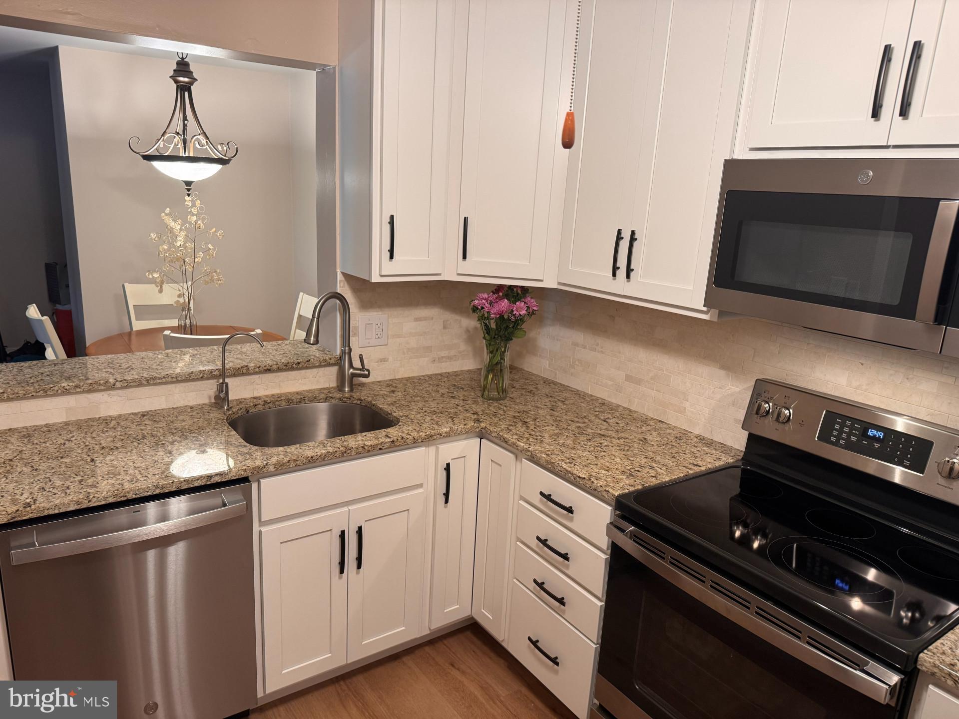 25 South Church Road, Unit 89 Maple Shade, NJ 08052 - Photo 10 of 24 a kitchen with stainless steel appliances granite countertop a sink stove and microwave