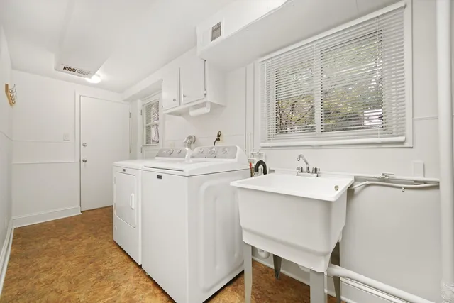 a utility room with cabinets washer and dryer