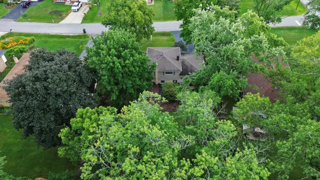 an aerial view of residential house with outdoor space and trees all around