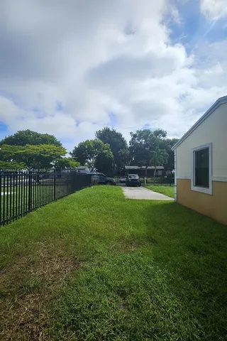 a view of a green field with wooden fence