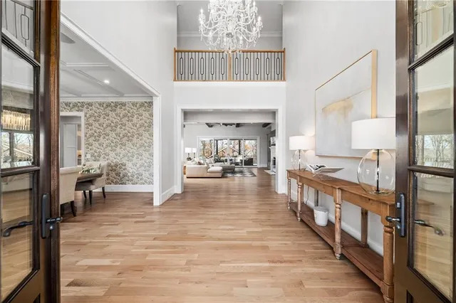 a large white kitchen with a large kitchen island white cabinets and stainless steel appliances