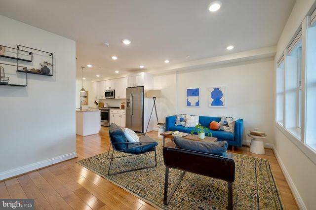 a living room with furniture and kitchen view