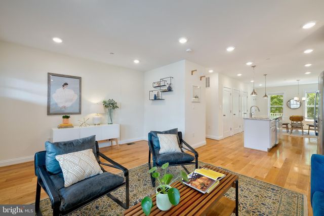 a living room with furniture and a dining table with wooden floor