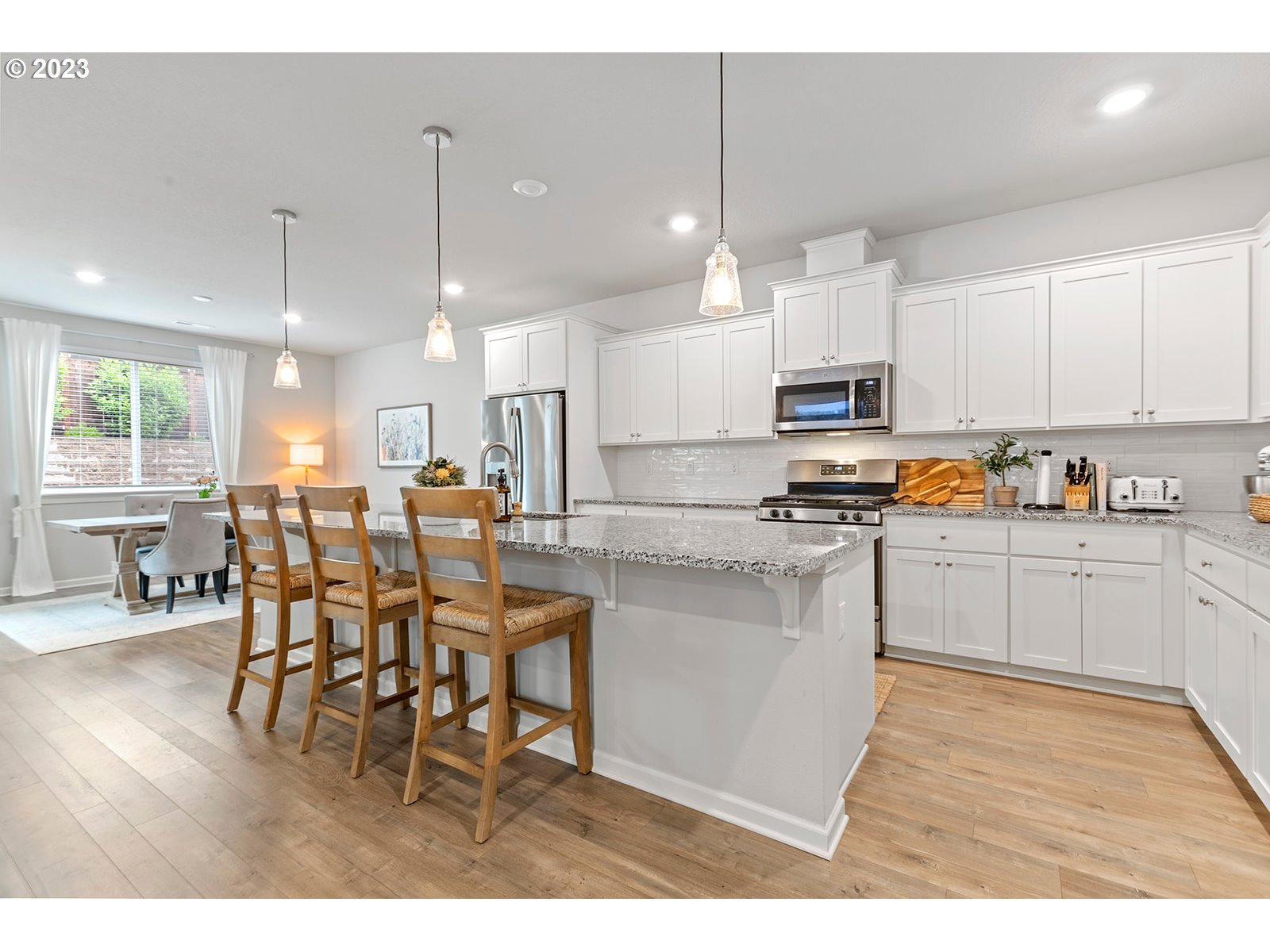 3722 South 39th Place Ridgefield, WA 98642 - Photo 11 of 45 a kitchen with stainless steel appliances kitchen island granite countertop a table chairs and a refrigerator
