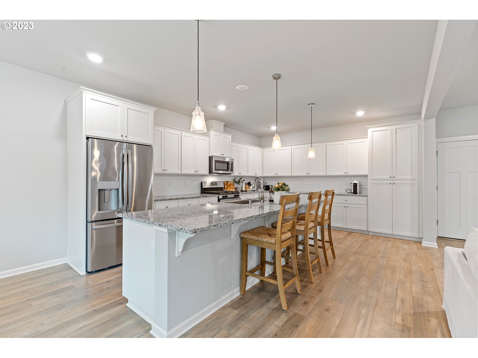 3722 South 39th Place Ridgefield, WA 98642 - Photo 14 of 45 a kitchen with stainless steel appliances kitchen island granite countertop a kitchen island a stove a refrigerator a sink a dining table and chairs