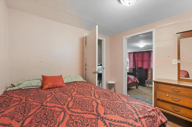 a bedroom with a bed and a flat tv screen on the dresser