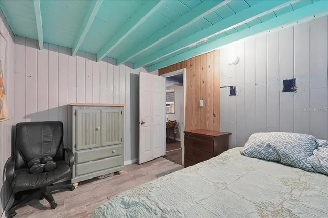 a bedroom with a bed and a painting on the wall