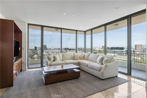a living room with furniture city view and large windows