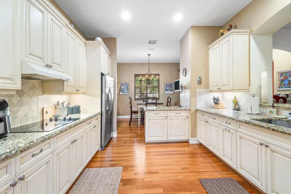 a large kitchen with stainless steel appliances kitchen island granite countertop a sink and cabinets