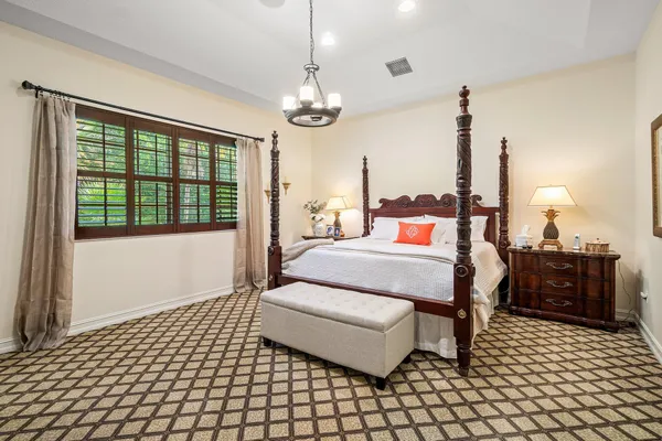a bedroom with a large bed and a chandelier