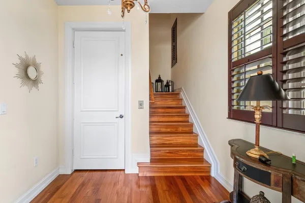 a view of a hallway with wooden floor and staircase