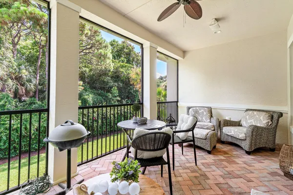 a balcony with chairs and a potted plant