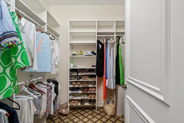 a view of walk in closet with clothes and shoes