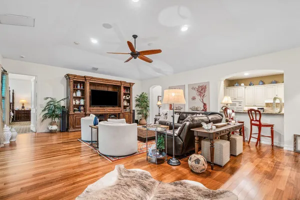 a living room with furniture kitchen view and a large window