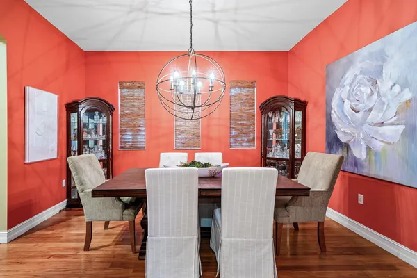 a view of a dining room with furniture a chandelier and wooden floor