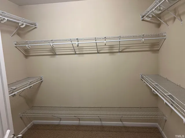 a view of walk in closet with empty racks
