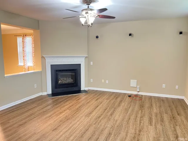 wooden floor fireplace and window in an empty room