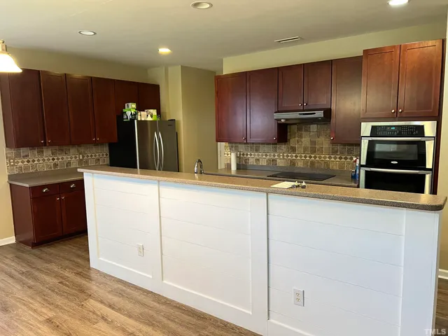 a kitchen with stainless steel appliances granite countertop a stove a sink and a microwave