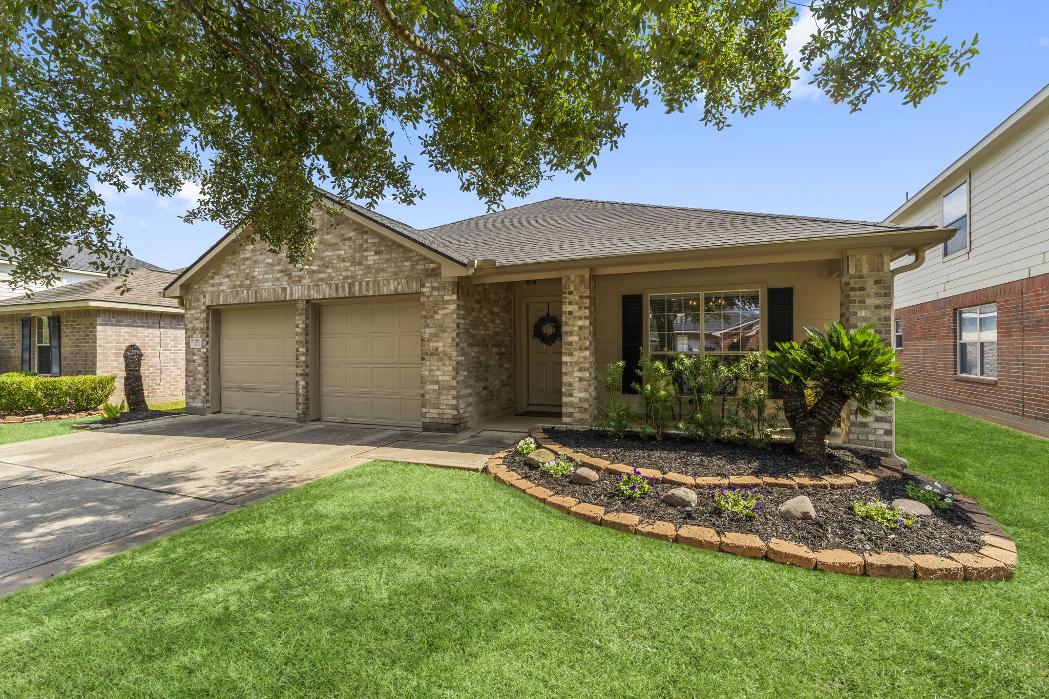 a view of a house with a yard and large tree