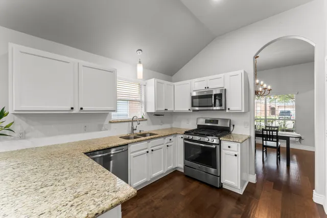 a kitchen with stainless steel appliances granite countertop a stove a sink and a microwave
