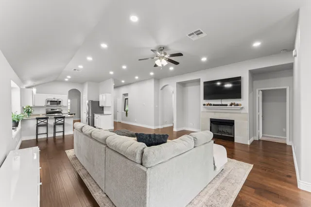 a living room with furniture a fireplace and a flat screen tv