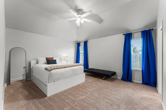 a bedroom with a bed and a ceiling fan