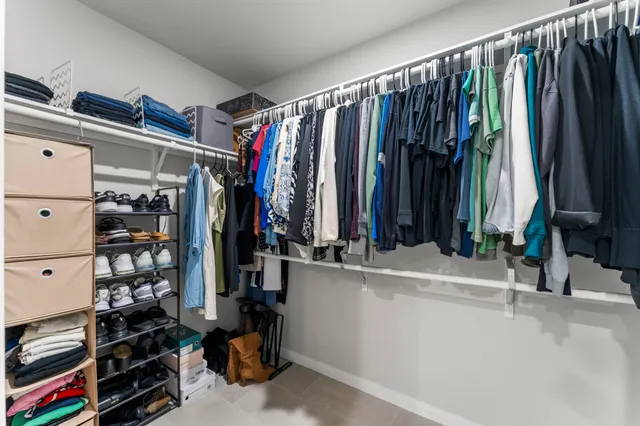 a view of walk in closet with clothes and shoes