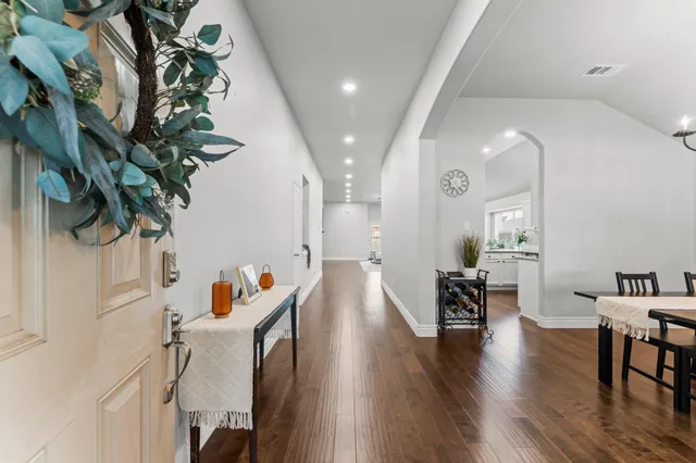 a hallway with wooden floor and furniture