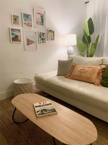 a living room with furniture and painting on the wall