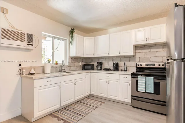 a kitchen with stainless steel appliances granite countertop a stove and white cabinets