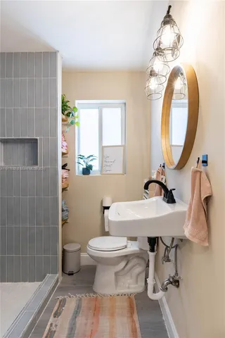 a bathroom with a sink a toilet and a mirror