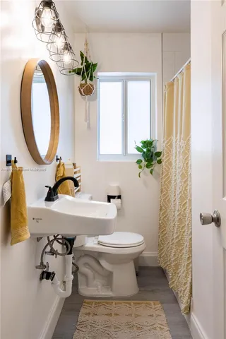 a bathroom with a sink a toilet and a mirror