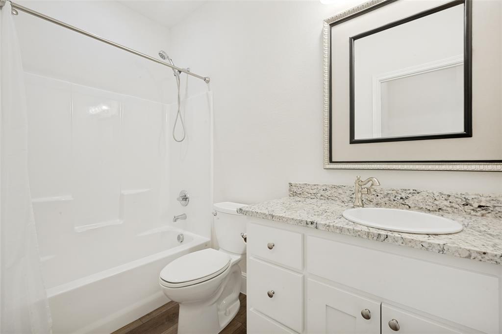 444 Ben Boyd Road Argyle, TX 76226 - Photo 22 of 28 a bathroom with a granite countertop toilet sink and mirror