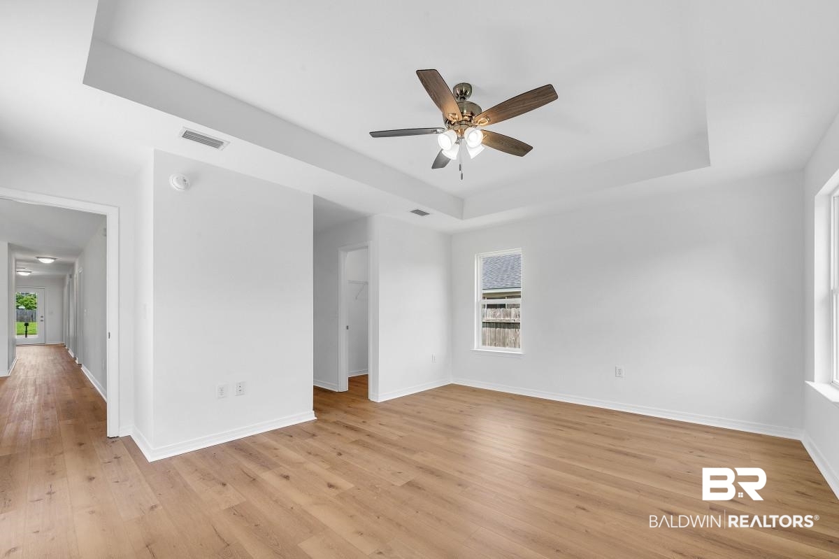 16927 Sugar Loop Foley, AL 36535 - Photo 22 of 50 Unfurnished room with a raised ceiling, light wood finished floors, ceiling fan, and a smoke detector
