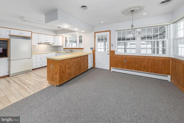 a large kitchen with stainless steel appliances granite countertop a large counter top and a stove