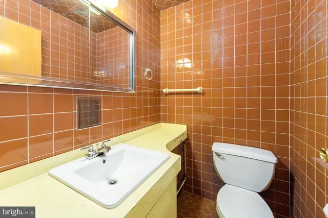 a bathroom with a sink a toilet and mirror