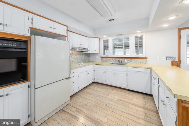 a kitchen with white cabinets and white appliances