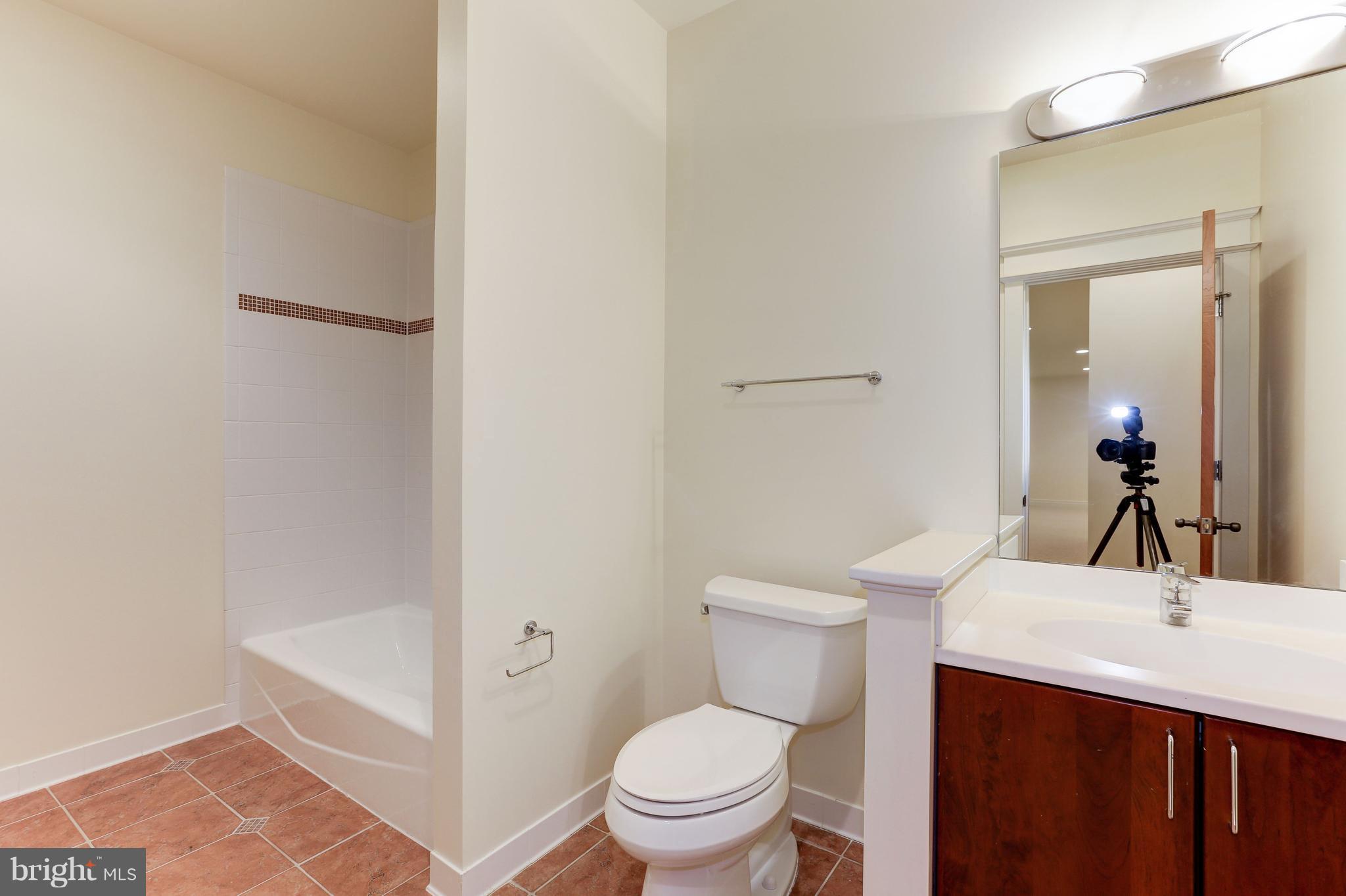 8610 Fernwood Road Bethesda, MD 20817 - Photo 27 of 30 a bathroom with a sink a toilet a mirror and shower
