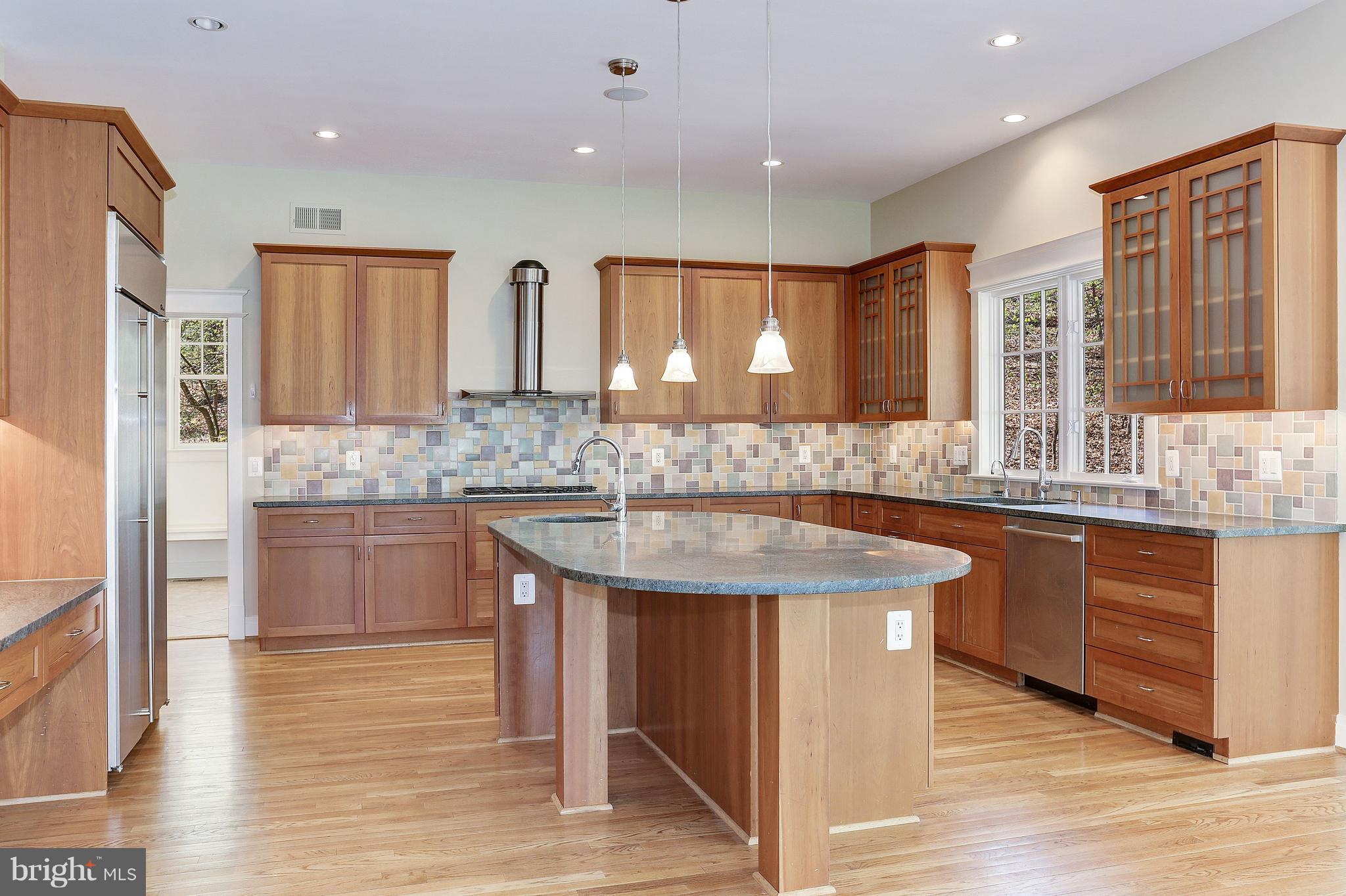 8610 Fernwood Road Bethesda, MD 20817 - Photo 7 of 30 a kitchen with stainless steel appliances granite countertop a sink stove and wooden cabinets