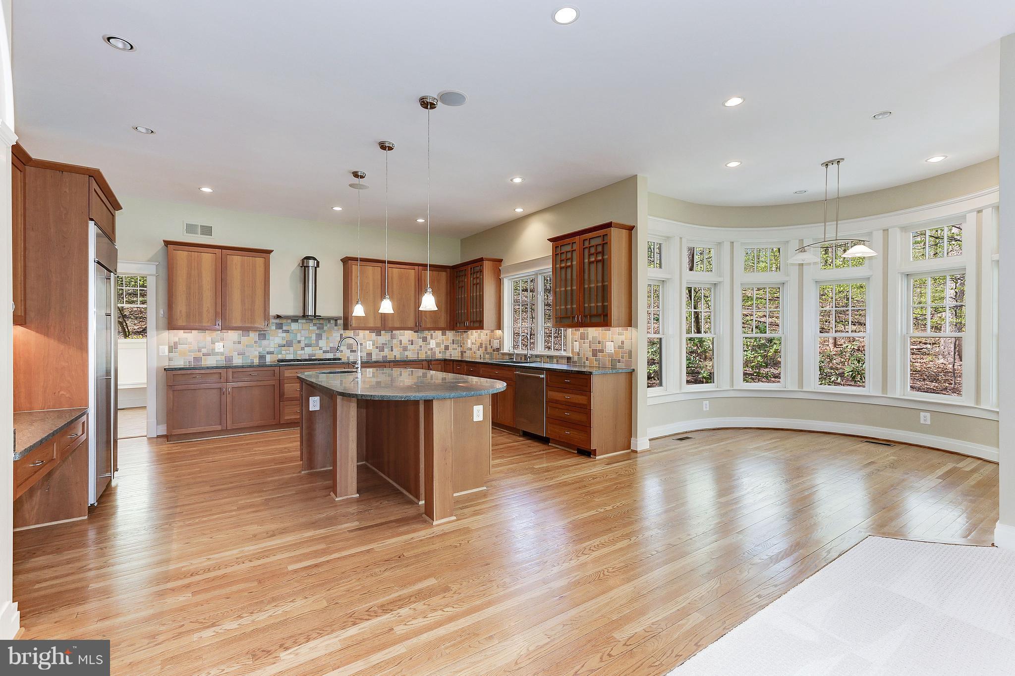 8610 Fernwood Road Bethesda, MD 20817 - Photo 9 of 30 a large kitchen with a large counter top a sink stainless steel appliances and cabinets