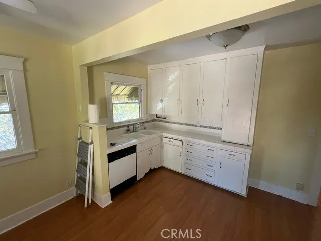 a kitchen with sink cabinets and wooden floor