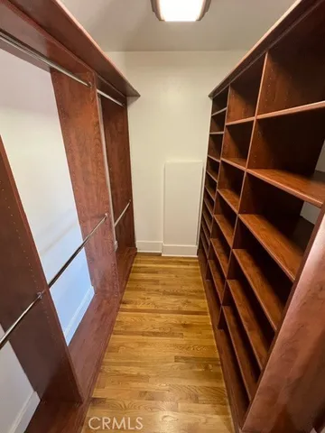 a view of walk in closet with wooden floor