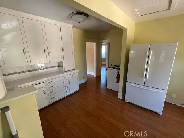 a view of a kitchen with cabinets and wooden floor