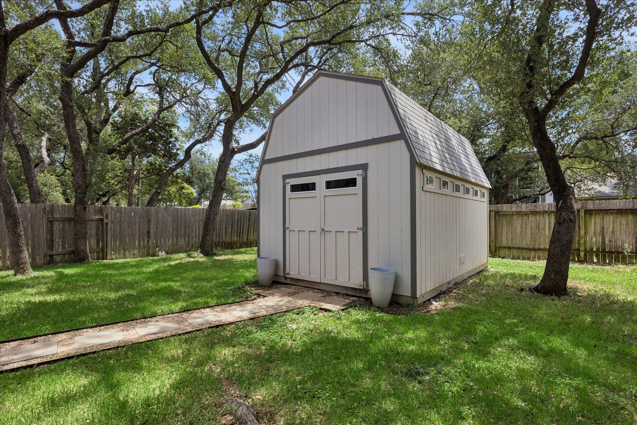 1306 Shady Grove Path Cedar Park, TX 78613 - Photo 37 of 40 a view of backyard with large trees and wooden fence