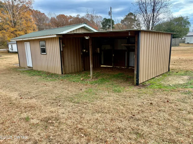 a view of a house with a small yard and wooden fence