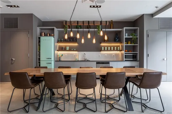 a living room with stainless steel appliances granite countertop furniture a rug a fireplace and a large window