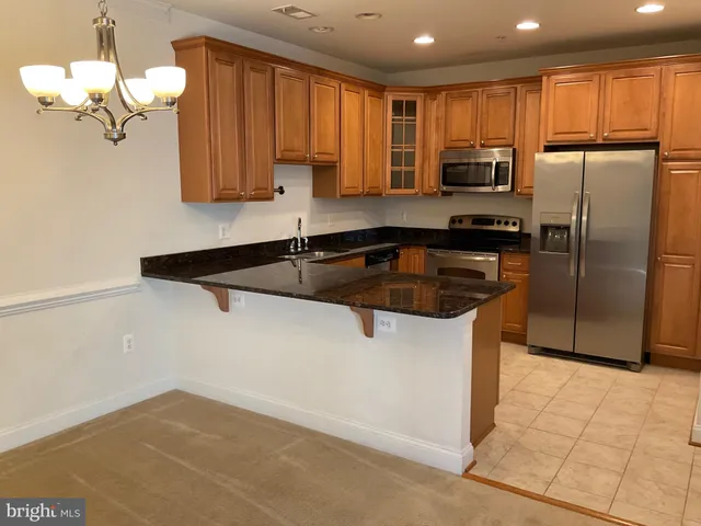 a kitchen with stainless steel appliances granite countertop a refrigerator a sink a stove a microwave and island