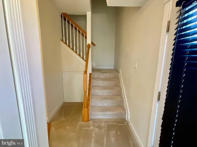 a view of staircase with wooden floor and white walls