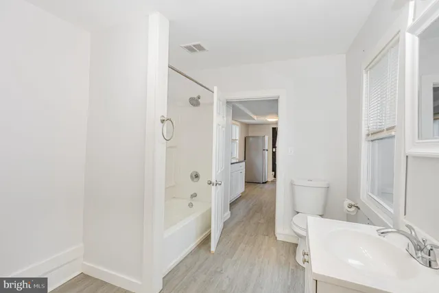 a bathroom with a bathtub sink and mirror