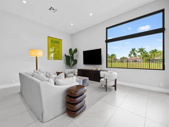 a living room with stainless steel appliances kitchen island a table and a couch